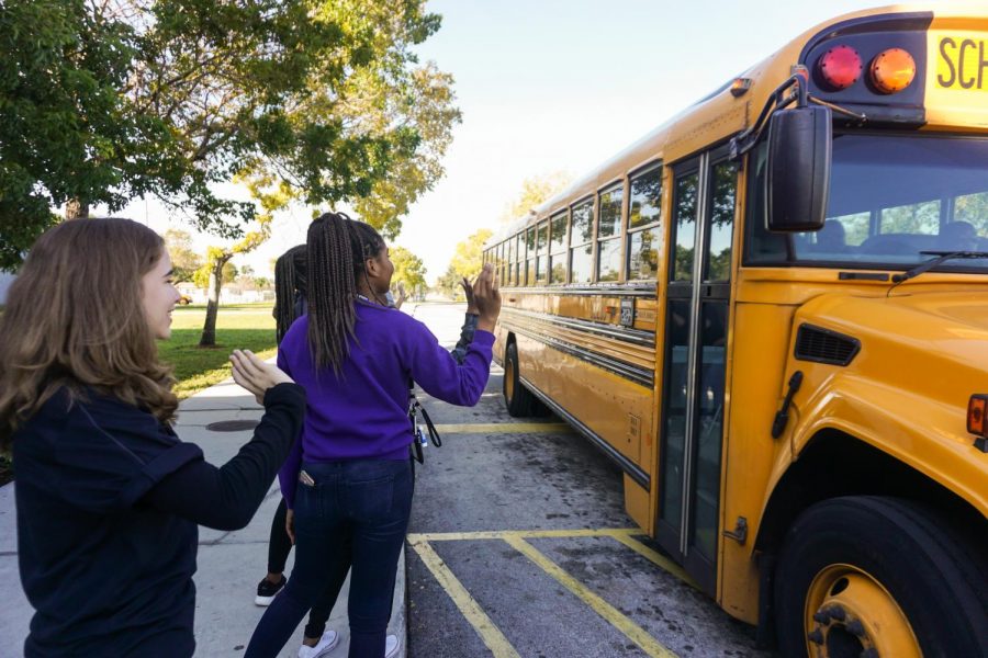 (From left to right) Junior Hannah Bregman and ____ greet a bus of eighth graders. About 800 eighth graders came to Krop for Lightning for a Day, an annual preview of high school.