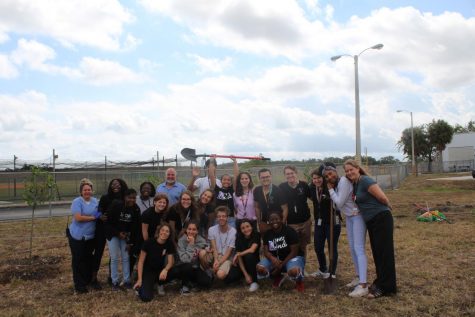 Students take group photo with staff after planting 17 Trees