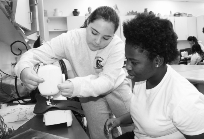 IN STYLE: During a club meeting, Vice President Naomi Zrihen assists a student with the sewing maching.