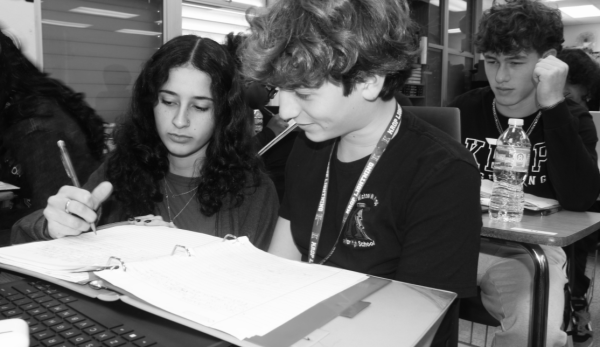 EDUCATING: Chemistry teacher Eden Assraf helps a student with their classwork during her 7th period chemistry class.