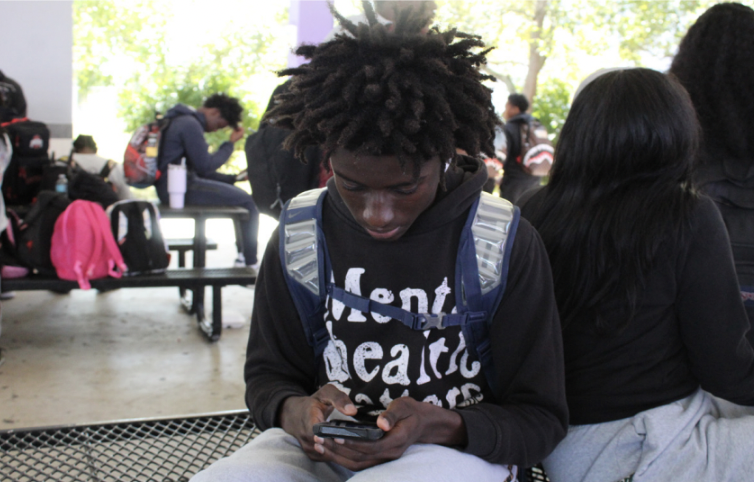 SCREEN TIME: Junior Freguy Mauscarie spends his lunch time on his 
phone.